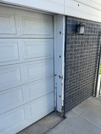 Peeling and weathered trim board beside a garage door, the kind of rot fascia repair fixes, in Salt Lake City, UT